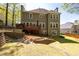 Rear exterior view of the house featuring a deck, brick landscaping, and a well-maintained lawn at 4016 Upland Trce, Marietta, GA 30066