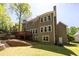 Rear exterior of the house featuring a deck, well-manicured lawn, and mature trees at 4016 Upland Trce, Marietta, GA 30066