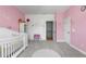 A cozy Bedroom with soft pink colors, a crib, and doorway at 895 Ovalene Sw Ln, Marietta, GA 30064