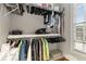 Well-organized closet with hanging clothes and shelved accessories in a neutral color scheme and natural lighting at 895 Ovalene Sw Ln, Marietta, GA 30064