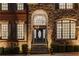 An elegant front door with stone and brick surround and manicured landscaping at 895 Ovalene Sw Ln, Marietta, GA 30064