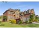 Stately brick and stone home with manicured landscaping on a lush green lawn and three-car garage at 895 Ovalene Sw Ln, Marietta, GA 30064