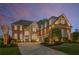 Brick facade home featuring an arched entryway, dormers, and a well manicured front lawn at 895 Ovalene Sw Ln, Marietta, GA 30064