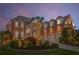 Elegant brick home with dormers, arched entryway, manicured lawn, and three-car garage at 895 Ovalene Sw Ln, Marietta, GA 30064