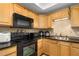 Well-maintained kitchen featuring black appliances, warm wood cabinets, and ample counter space at 895 Ovalene Sw Ln, Marietta, GA 30064