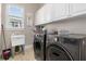 Well-equipped laundry room with modern washer and dryer, utility sink, and ample storage at 895 Ovalene Sw Ln, Marietta, GA 30064