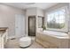 Relaxing main bathroom features a soaking tub, tiled shower, and decorative window at 895 Ovalene Sw Ln, Marietta, GA 30064
