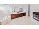 Luxurious bathroom features marble tile, a fireplace, a soaking tub, and beautiful dark wood cabinetry at 1081 Humphries Nw Rd, Conyers, GA 30012
