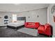 Relaxing bedroom boasts a red couch, cozy fireplace and plush king-sized bed, perfect for unwinding at 1081 Humphries Nw Rd, Conyers, GA 30012
