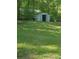 Storage shed set in a lush green backyard with lots of available outdoor space at 4775 Ben Hill Rd, Douglasville, GA 30134