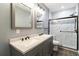 Bathroom featuring a double vanity, granite countertop, and glass-enclosed shower with decorative tile accents at 617 Wexford Ct, Acworth, GA 30102