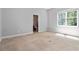 Simple bedroom with neutral carpeting, a window, and an attached bathroom, providing a blank canvas at 617 Wexford Ct, Acworth, GA 30102