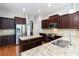 Kitchen with stainless steel appliances, granite counters, dark wood cabinets, and a central island at 617 Wexford Ct, Acworth, GA 30102