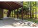 Covered concrete patio area surrounded by mature landscaping and a wood staircase at 617 Wexford Ct, Acworth, GA 30102