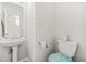 Clean powder room with pedestal sink, toilet, and mirrored wall cabinet, offering a fresh and functional space at 782 Ridgeland Trl, Clarkston, GA 30021