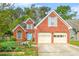 Charming two-story brick home with a manicured front yard, two-car garage, and inviting turquoise front door at 782 Ridgeland Trl, Clarkston, GA 30021