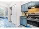 Kitchen with blue cabinets, stainless steel appliances, and easy access to laundry area at 782 Ridgeland Trl, Clarkston, GA 30021