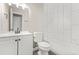 A modern bathroom features white marble-look tiling, with sleek fixtures and finishes at 1158 Crystal Lake Rd, Atlanta, GA 30349