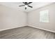 A bright bedroom with a ceiling fan and window, enhanced by modern wood-look flooring at 1158 Crystal Lake Rd, Atlanta, GA 30349