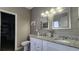 Bathroom featuring double sink vanity with granite countertops, framed mirrors, and modern lighting at 116 Ridge Xing, Temple, GA 30179