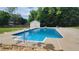 A sparkling in-ground pool with a concrete surround and mature trees at 116 Ridge Xing, Temple, GA 30179