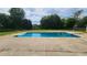 A spacious pool with metal ladder is surrounded by a concrete deck and a large grassy yard at 116 Ridge Xing, Temple, GA 30179