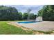 A spacious pool with metal ladder is surrounded by a concrete deck and a large grassy yard at 116 Ridge Xing, Temple, GA 30179