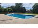 An in-ground pool set into concrete features lush grass, mature trees and ample sunlight at 116 Ridge Xing, Temple, GA 30179