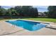 A spacious pool with diving board and ladder is surrounded by a concrete deck and a large grassy yard at 116 Ridge Xing, Temple, GA 30179