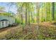 Backyard featuring mature trees and the home's rear facade and wooden deck at 4510 Trumble Ter, Snellville, GA 30039
