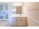Bathroom vanity with white countertop and cabinets, mirror, and French doors at 4510 Trumble Ter, Snellville, GA 30039