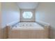 Bright bathroom showcasing a large soaking tub beneath an octagon window with tiled accents at 4510 Trumble Ter, Snellville, GA 30039