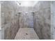 Tiled shower with mosaic flooring and stone walls featuring built in shelves at 4510 Trumble Ter, Snellville, GA 30039