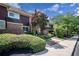 Exterior angle view of a townhome with lush landscaping, healthy trees, and well-manicured shrubs at 69 Country Place Ct, Alpharetta, GA 30005