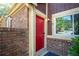 Close-up of a bright red front door with a brick surround and visible house number at 69 Country Place Ct, Alpharetta, GA 30005
