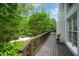 Back deck area with wood floors and railings, overlooking the backyard pool and lounge area at 7000 Hunters Knl, Atlanta, GA 30328