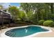 Backyard pool surrounded by lush landscaping, greenery, trees, and a two-story deck area at 7000 Hunters Knl, Atlanta, GA 30328