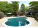 Backyard pool is surrounded by a lounge area, landscaping, and greenery at 7000 Hunters Knl, Atlanta, GA 30328