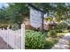Decatur Square Condominiums sign surrounded by lush greenery and a white picket fence at 1181 Church St # D, Decatur, GA 30030