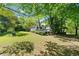 View of the back of the house with a deck overlooking the spacious backyard and wooded area at 3200 Hampton Ridge Way, Snellville, GA 30078