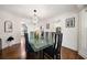 Formal dining room with modern chandelier, glass table, wainscoting, and hardwood flooring at 3200 Hampton Ridge Way, Snellville, GA 30078