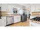 Well-lit kitchen with stainless steel appliances, granite countertops, and white cabinets at 3200 Hampton Ridge Way, Snellville, GA 30078