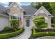 Charming home exterior featuring a manicured lawn, gray brick, arched windows, and a cozy front porch at 3601 Cedar Springs Ln, Loganville, GA 30052