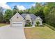Charming brick home featuring an attached two-car garage, manicured lawn, and lush landscaping at 3601 Cedar Springs Ln, Loganville, GA 30052