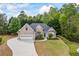 Charming brick home featuring an attached two-car garage, manicured lawn, and lush landscaping at 3601 Cedar Springs Ln, Loganville, GA 30052