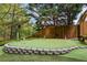 Artificial turf putting green with stone borders, flags, and a birdbath at 3601 Cedar Springs Ln, Loganville, GA 30052