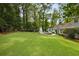 Spacious backyard with a large lawn, a patio seating area, and a playground at 568 Timberland Dr, Atlanta, GA 30342