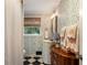 Quaint bathroom with patterned wallpaper, a pedestal sink, and a window at 568 Timberland Dr, Atlanta, GA 30342