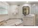 Bright bathroom featuring a soaking tub, marble countertops, storage, and a glass-enclosed shower at 568 Timberland Dr, Atlanta, GA 30342