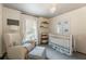 Bright Bedroom featuring a crib, cozy chair, and soft, calming decor at 568 Timberland Dr, Atlanta, GA 30342